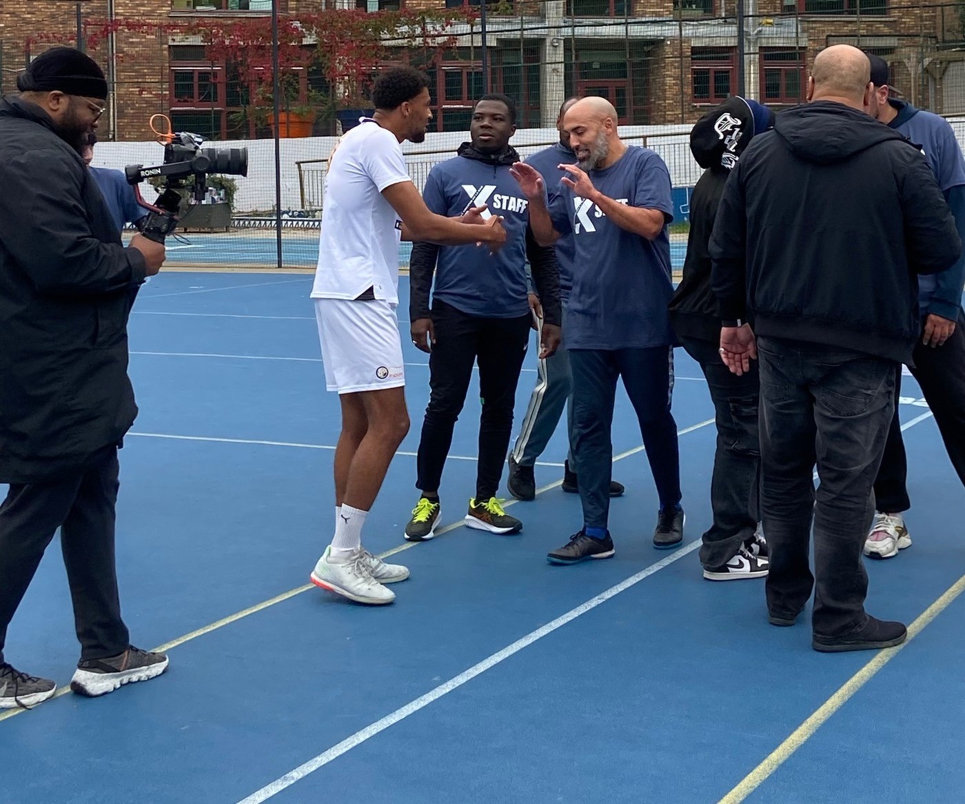 Joueurs et intervenants réunis sur un city stade parisien pendant un événement StreetFoot.