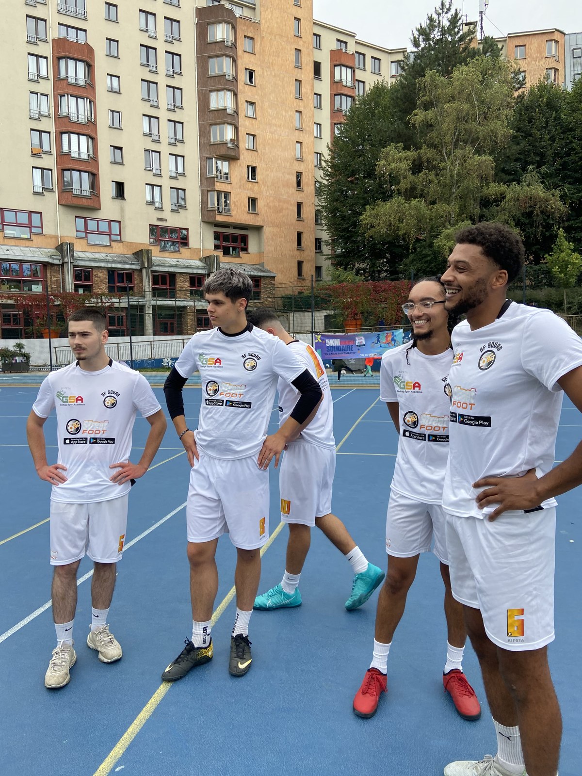 Équipe StreetFoot en maillots blancs sur un city stade parisien.